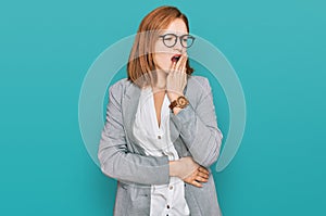 Young caucasian woman wearing business style and glasses bored yawning tired covering mouth with hand