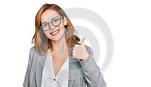 Young caucasian woman wearing business style and glasses doing happy thumbs up gesture with hand