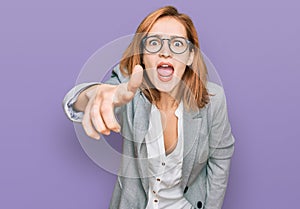 Young caucasian woman wearing business style and glasses pointing displeased and frustrated to the camera, angry and furious with