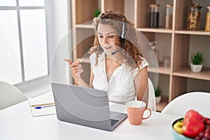 Young caucasian woman wearing call center agent headset working from home smiling happy pointing with hand and finger