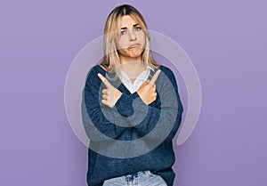 Young caucasian woman wearing casual clothes pointing to both sides with fingers, different direction disagree