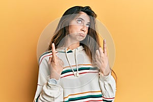 Young caucasian woman wearing casual clothes pointing up looking sad and upset, indicating direction with fingers, unhappy and