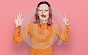 Young caucasian woman wearing casual clothes showing and pointing up with fingers number seven while smiling confident and happy