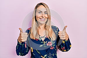 Young caucasian woman wearing casual clothes success sign doing positive gesture with hand, thumbs up smiling and happy