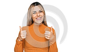 Young caucasian woman wearing casual clothes success sign doing positive gesture with hand, thumbs up smiling and happy