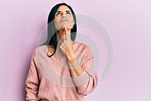 Young caucasian woman wearing casual clothes thinking concentrated about doubt with finger on chin and looking up wondering