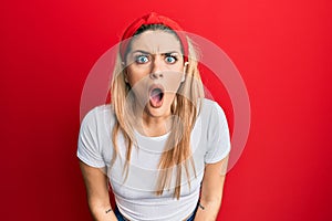 Young caucasian woman wearing casual white t shirt afraid and shocked with surprise and amazed expression, fear and excited face