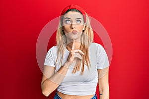 Young caucasian woman wearing casual white t shirt thinking concentrated about doubt with finger on chin and looking up wondering photo