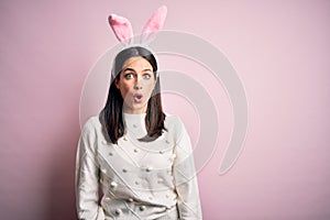 Young caucasian woman wearing cute easter rabbit ears over pink isolated background afraid and shocked with surprise expression,