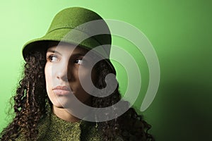 Young Caucasian woman wearing green clothing and hat.