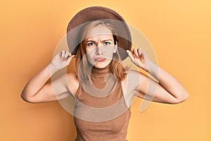 Young caucasian woman wearing hat depressed and worry for distress, crying angry and afraid