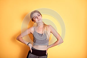 Young caucasian woman wearing in sports bra over isolated background smiling with hands on hips with closed eyes and