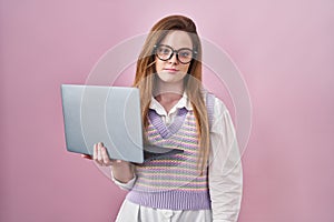 Young caucasian woman working using computer laptop looking sleepy and tired, exhausted for fatigue and hangover, lazy eyes in the