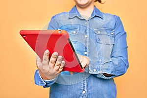 Young caucasian woman working using tablet standing over isolated yellow background