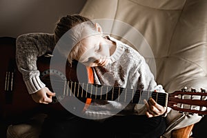 A young caucasion girl practicing playing her guitar