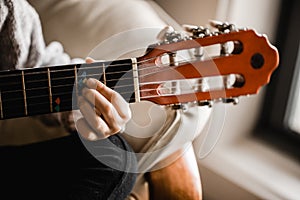 A young caucasion girl practicing playing her guitar