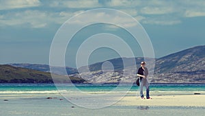 Young Caucassian woman enjoying holiday on a white sandy beach with turquoise water