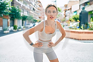 Young cauciasian fitness woman wearing sport clothes training outdoors, resting tired