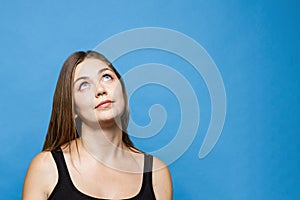 Young causacian woman with blue eyes up thinks or dreams about something.