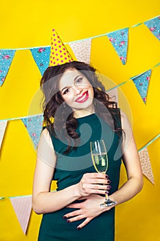 Young celebrating woman green dress, holding a glass of champagne.