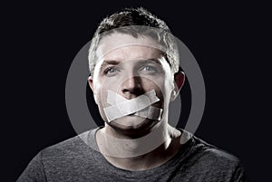 Young censored man mouth sealed on tape to prevent free speaking photo