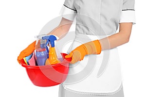 Young chambermaid holding basin with cleaning supplies
