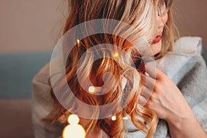 Young charming blonde woman in glasses with lights in her hair, romantic atmospheric photo about dreams