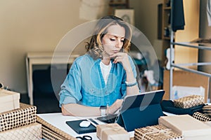 Young charming caucasian woman is working on a tablet. photo