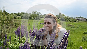 Young charming girl with wildflowers lupins