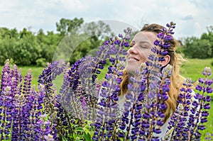 Young charming girl with wildflowers lupins