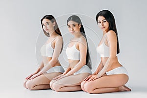 young charming multicultural women posing in white underwear