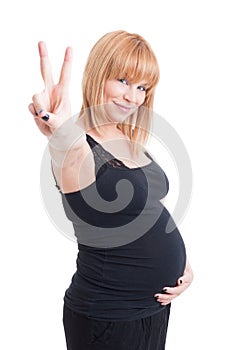 Young charming pregnant woman showing peace or victory sign