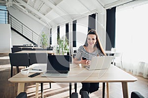 Young charming woman calling with cell telephone while sitting alone in coffee shop during free time, attractive female