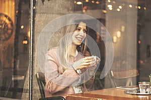 Young charming woman spend time while sitting in coffee shop during free time, attractive female with cute smile having talking