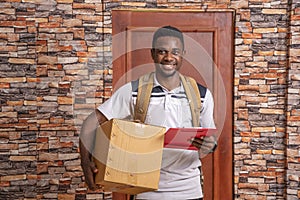 Young cheerful African courier delivering parcel in a large box