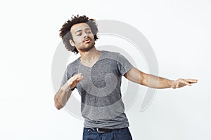 Young cheerful african man moving dancing over white background.