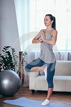 Young cheerful attractive woman practicing yoga