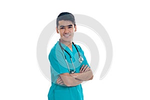 Young cheerful brunette man doctor in blue uniform with stethoscope on his shoulders smiling on camera isolated on white