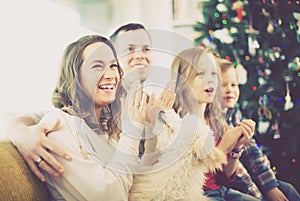 Young cheerful family enjoying Christmas evening at home