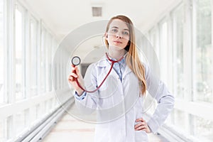 Young cheerful female doctor portrait with a stethoscope in clinic