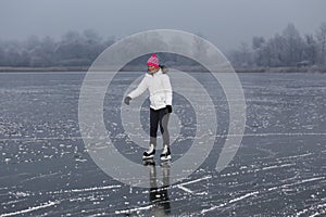 Young cheerful girl skating on the lake.