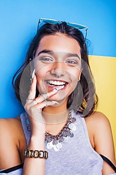 Young cheerful indian mixed races girl happy smiling, posing on blue background in summer fashion clothers. lifestyle