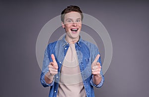 Young cheerful man showing thumbs up with positive emotions