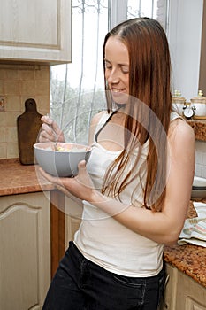 Young cheerful millennial woman,girl preparing fresh lunch,dinner, cooking vegetable salad with eggs,dinner in home kitchen