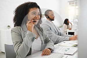 Young cheerful mixed race female call center agent answering calls while wearing a headset at work. Hispanic