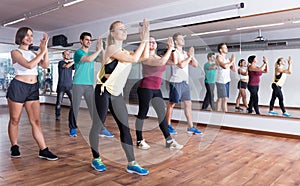 Young cheerful people dancing zumba elements photo