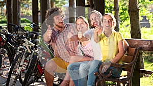 Young cheerful people gesturing thumbs up.