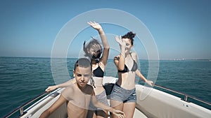 Young cheerful people having fun in boat party