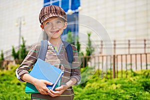 Young cheerful schoolboy with books