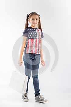 Young and cheerful shopping girl with shopping bags on white background